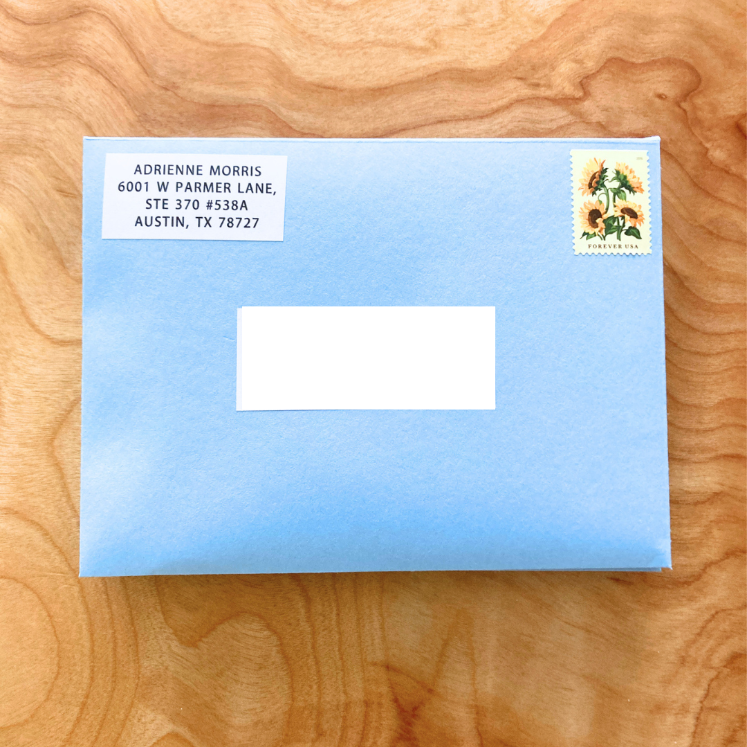 Blue envelope with address label and stamp on a wooden surface