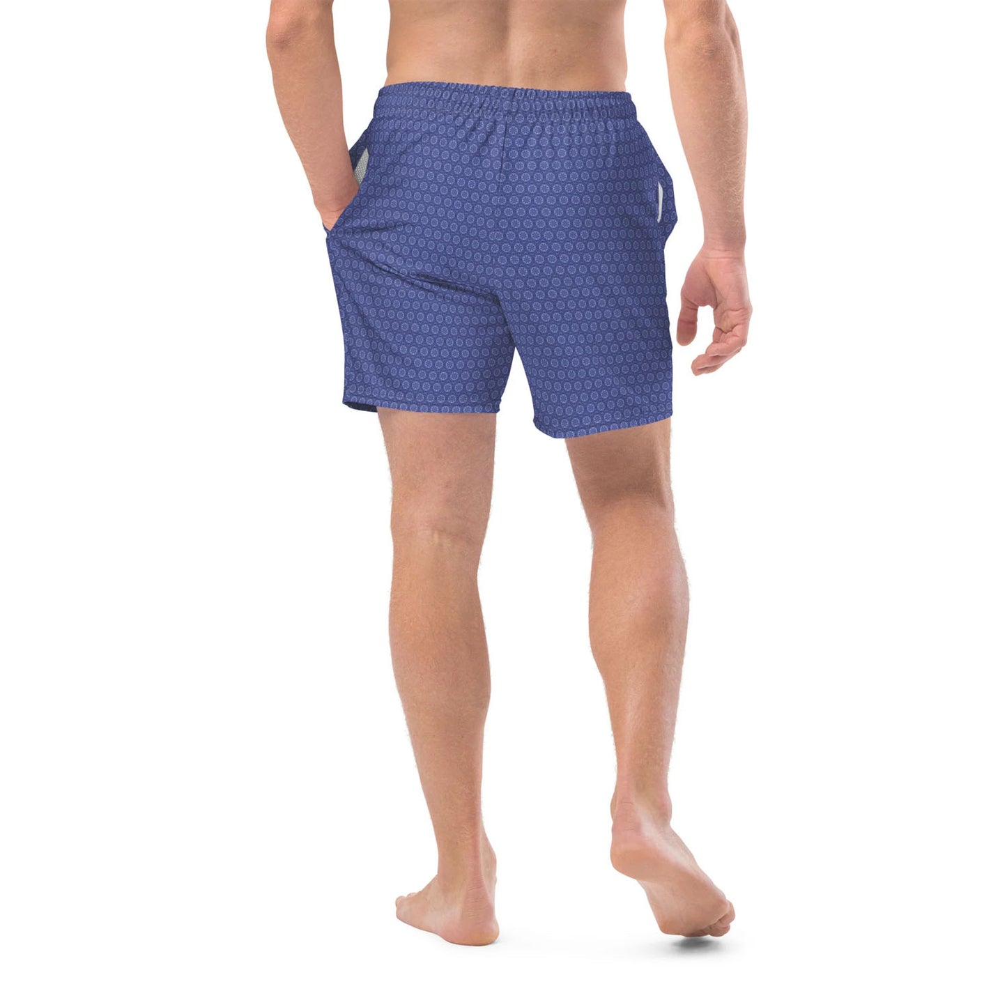 Blue patterned swim shorts worn by a person on a white background