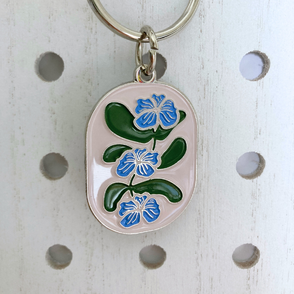 Front view of Flower Vine Soft Enamel Split Ring Keychain  hanging on a white peg board.