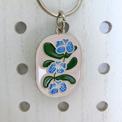 Front view of Flower Vine Soft Enamel Split Ring Keychain  hanging on a white peg board.