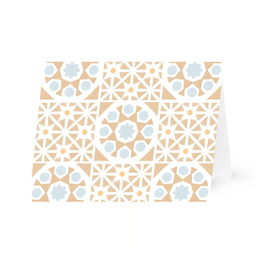 A horizontal greeting card featuring an all-over pattern of tan-colored Mediterranean tiles arranged in a symmetrical grid format. The folded is shown slightly propped open and centered against a plain white background.