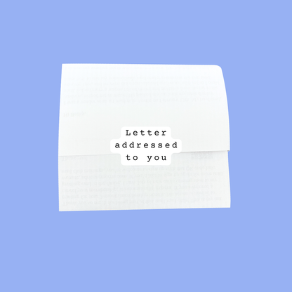 A white paper letter and matching envelope with a small printed label reading 'Letter addressed to you' in the center, shown on a solid light blue background.